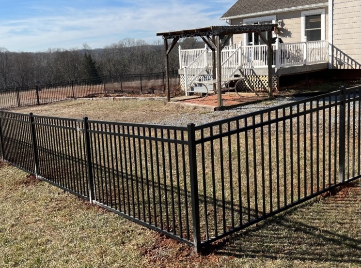 Black aluminum fence wrapping a backyard and deck